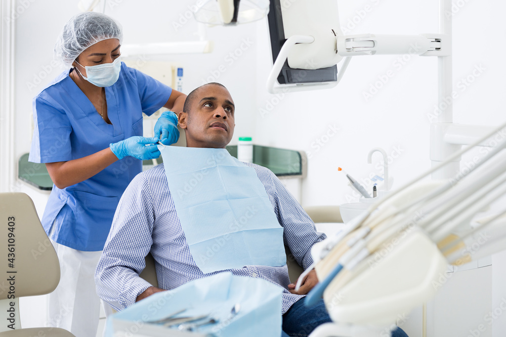 Obraz premium Dental assistant prepares the patient for surgery