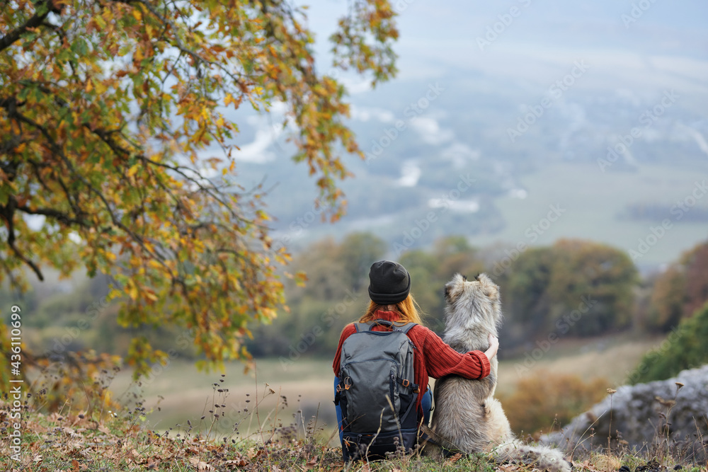 woman hiker next to dog admires nature mountains travel