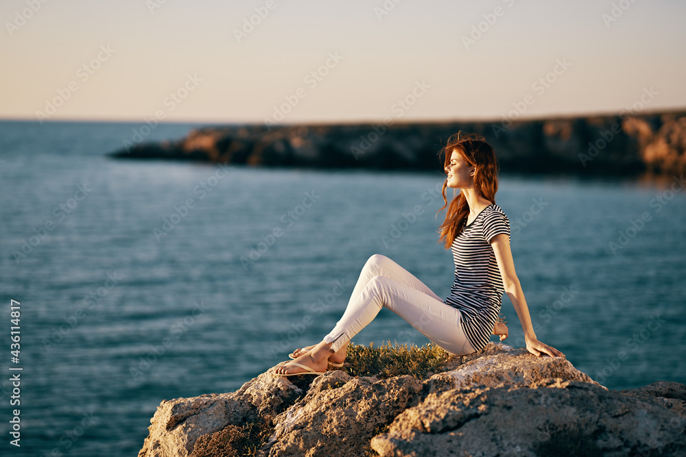 woman in the mountains sits on the seashore nature landscape woman in the mountains sits on the seashore nature landscape