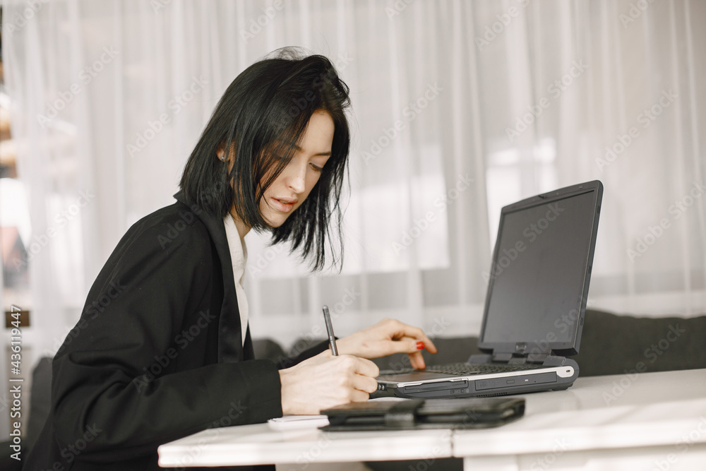 Girl in a business suit works in a loptop Girl in a business suit works in a loptop