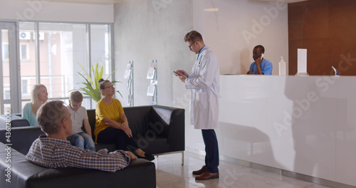 People sitting in waiting room of modern medical clinic.