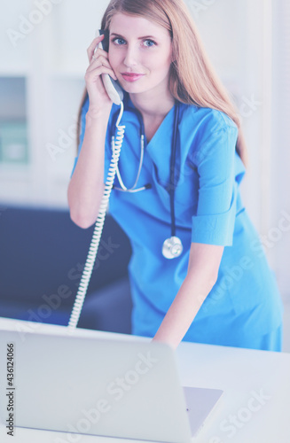 Female doctor talking on phone in diagnostic center photo