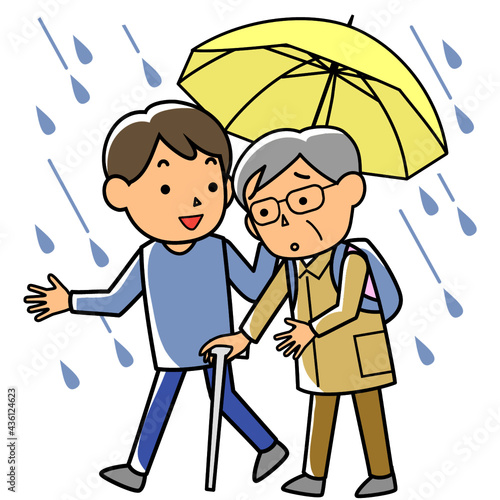 雨の中避難する高齢者を支援する男性