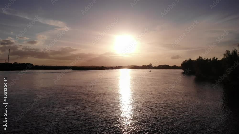 Bright Sky Over Serene Inland Waterway With Bulk Carrier Traveling During Sunrise. - Aerial Shot Bright Sky Over Serene Inland Waterway With Bulk Carrier Traveling During Sunrise. - Aerial Shot