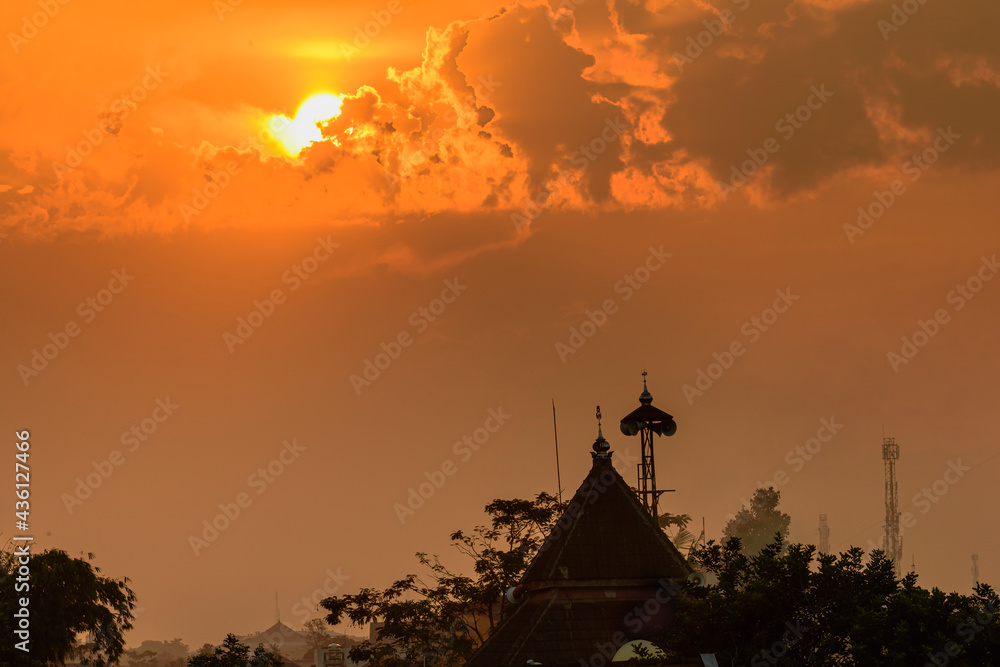Mosque dome and minaret silhouette with golden burning sky sunset background