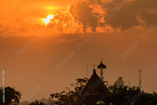 Mosque dome and minaret silhouette with golden burning sky sunset background