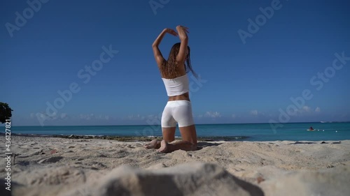 Young flexible fit woman dancing on the beach with sand in slow motion. Freedom, Individuality and originality concept 