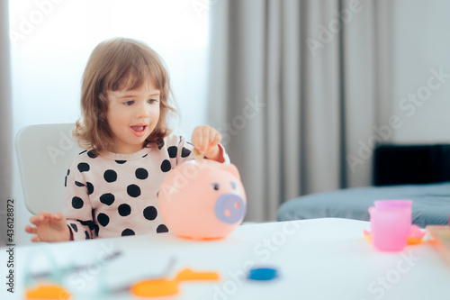 Happy Toddler Girl Saving Money with Piggy Bank