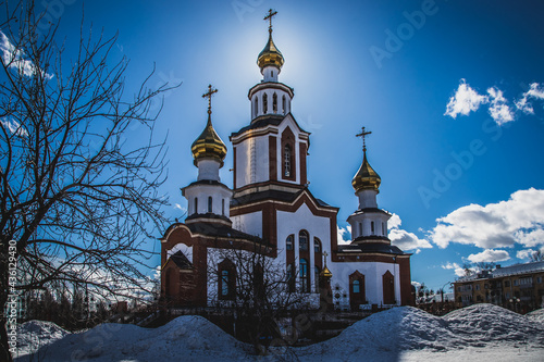 the bright spring sun peeps out from behind the golden domes of the Orthodox church