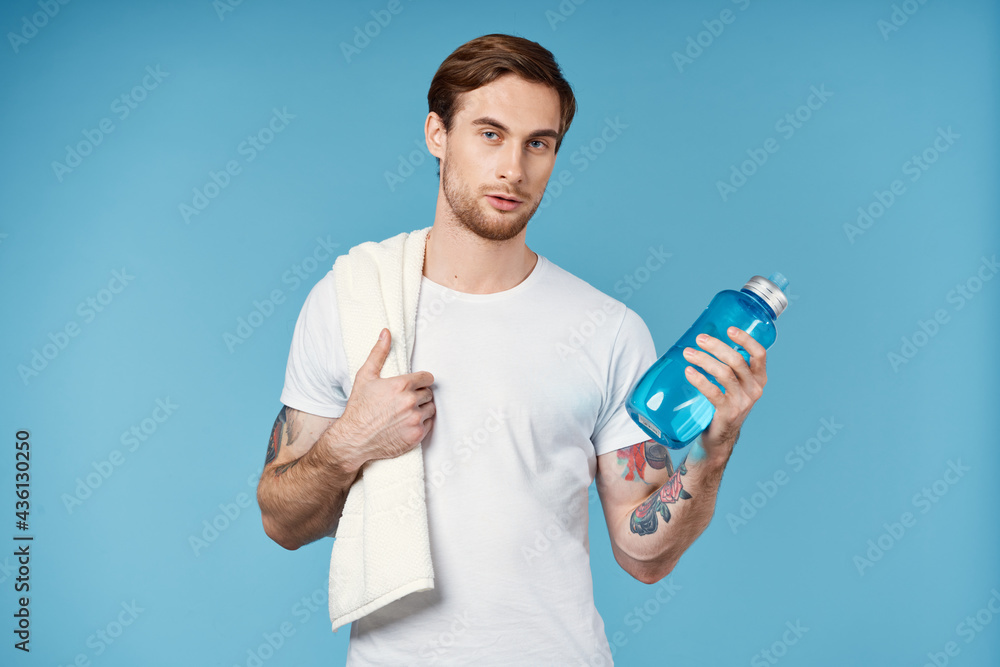 sport man with tattoos on his arms water bottle energy blue background sport man with tattoos on his arms water bottle energy blue background