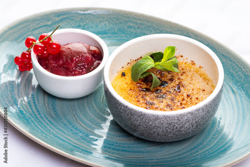 Dessert creme brulee and red currant sauce Dessert creme brulee and red currant sauce