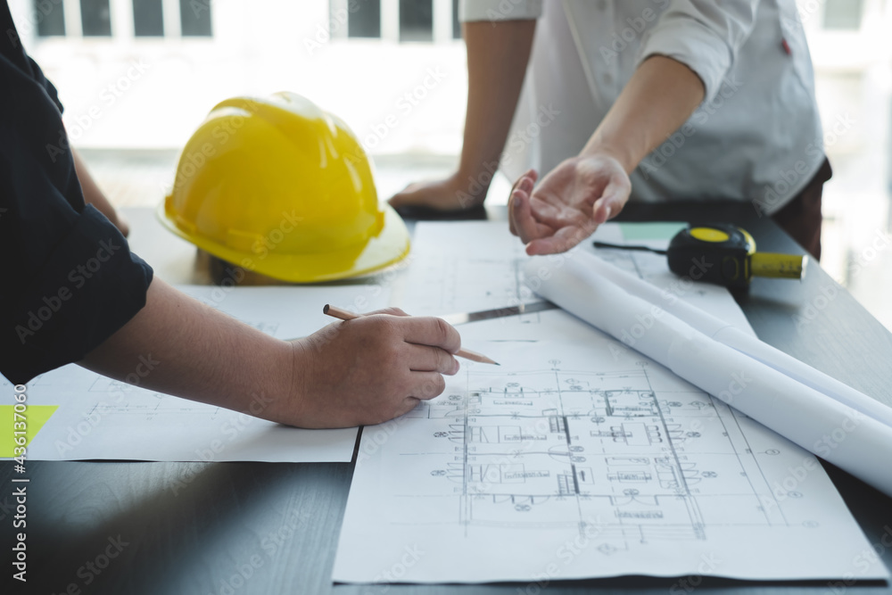 Team of engineers and architects, working team, meeting, discussing construction and drawing construction plans, printing, writing on-site construction sites. Home design concept Team of engineers and architects, working team, meeting, discussing construction and drawing construction plans, printing, writing on-site construction sites. Home design concept