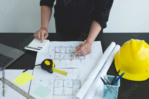 Architects or engineers working construction and drawing construction plans, printing, writing on-site construction sites. Home design concept