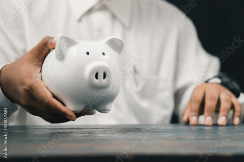 Fotografia Investors or professional businessmen wearing gloves with a piggy bank Money sav