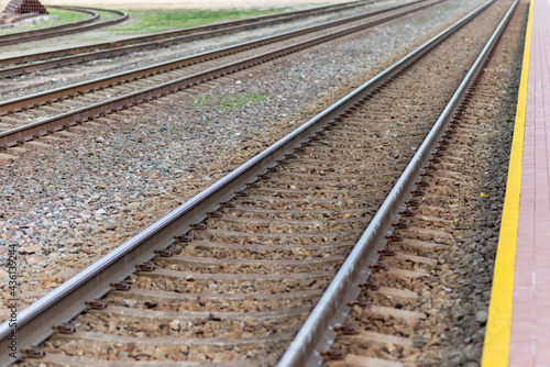 Railroad tracks urban shoot. Leading line view.iron rusty train railway over dark stones rail way
