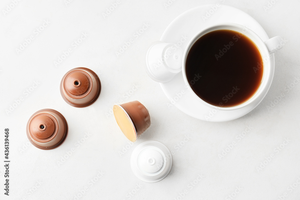 Cup of coffee with capsules on table Cup of coffee with capsules on table