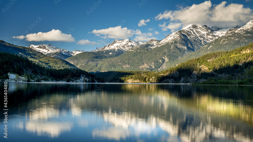 Sunset over the Garibaldi Range and the Mountains Reflecting on the smooth surface of Green Lake near Whistler, British Columbia, Canada