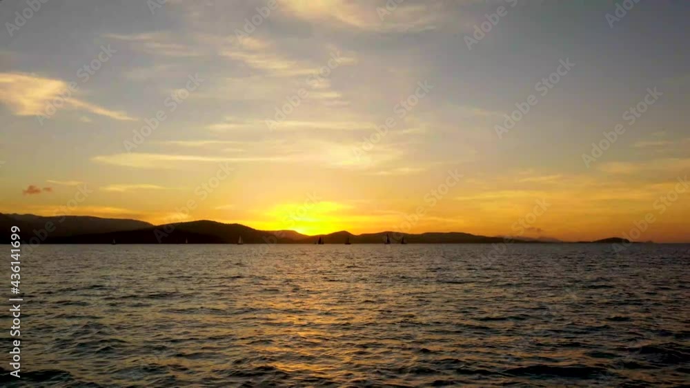 Taken from another boat A mumber of racing Sail boats can be seen silhouetted against a colorful skyline by the sunset off the coast of Airlie Beach in North Queensland Australia. Taken from another boat A mumber of racing Sail boats can be seen silhouetted against a colorful skyline by the sunset off the coast of Airlie Beach in North Queensland Australia.