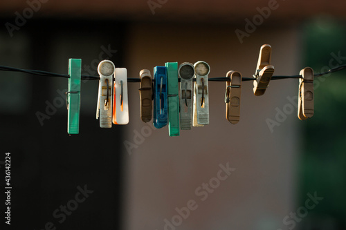 Colorful plastic clothes pegs on white clothesline, fashion business concept