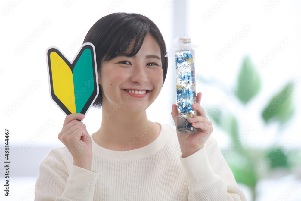 ハーバリウムと初心者マークを持つ女性