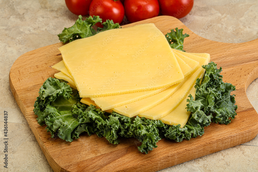Sliced Gauda cheese over board Sliced Gauda cheese over board