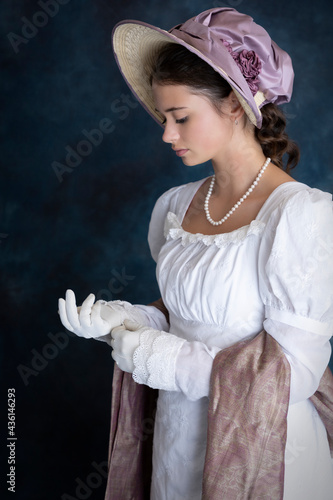 A young Regency woman wearing a white muslin dress and a straw bonnet