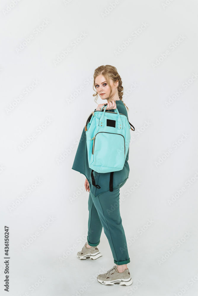 beautiful stylish women's backpack-briefcase of a schoolboy and a student on a white background of a copy space. the girl holds an aquamarine bag for study, school and college, recreation and daily wa