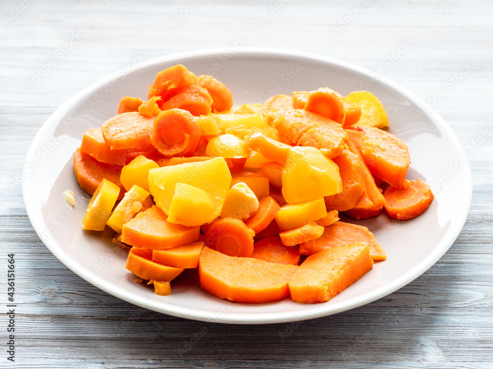 sliced steamed vegetables on plate on gray table sliced steamed vegetables on plate on gray table