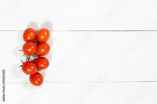 cherry tomatoes on a white wooden background with place for text