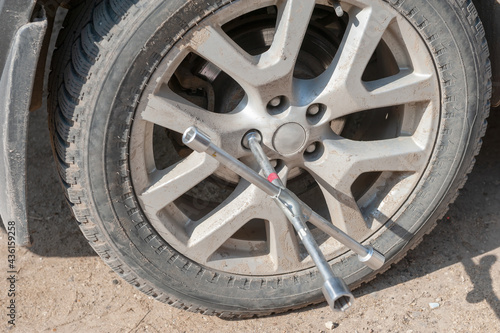 Wheel replacement on the road by the driver. Replacing summer tires with winter tires with a handy wrench by a mechanic after balancing the wheels in close-up