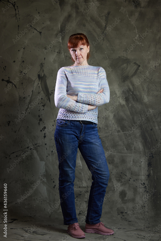 Portrait of a Caucasian woman in full growth in jeans in a studio on gray background. High resolution photos Portrait of a Caucasian woman in full growth in jeans in a studio on gray background. High resolution photos