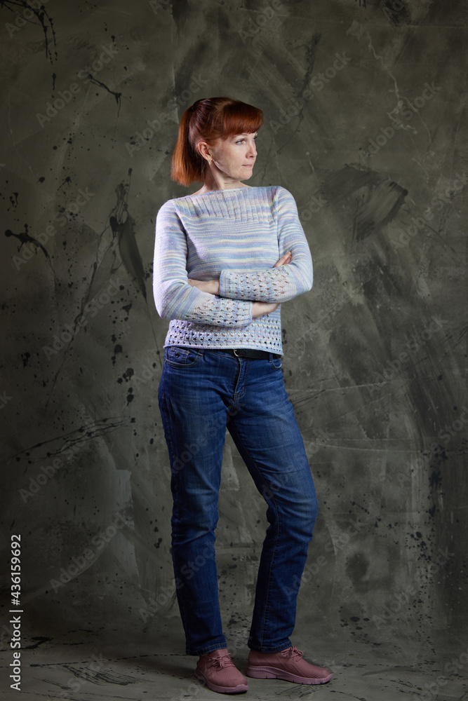 Portrait of a Caucasian woman in full growth in jeans in a studio on gray background. High resolution photos Portrait of a Caucasian woman in full growth in jeans in a studio on gray background. High resolution photos
