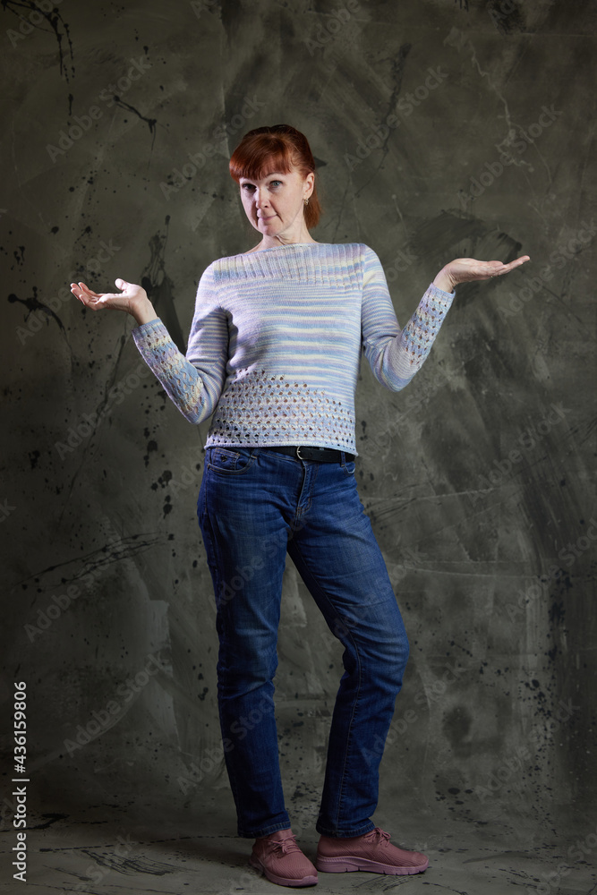Portrait of cute Caucasian woman posing in full growth in jeans in studio on gray background. High resolution photos
