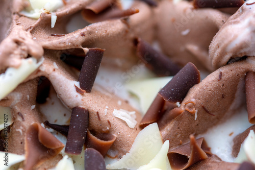 Macro on chocolate and vanilla ice cream with sweet flakes 