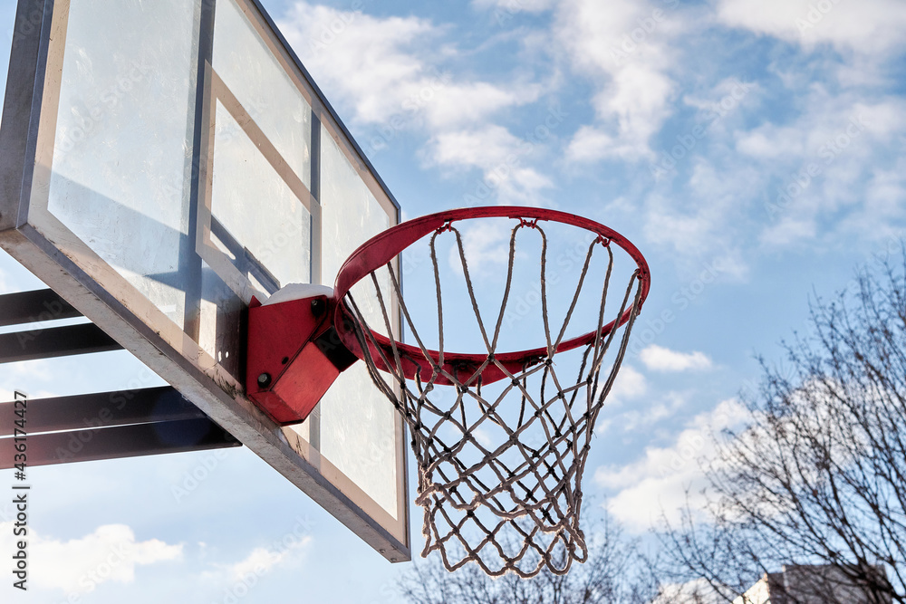 Basketball hoop and blue sky with clouds on the background Basketball hoop and blue sky with clouds on the background