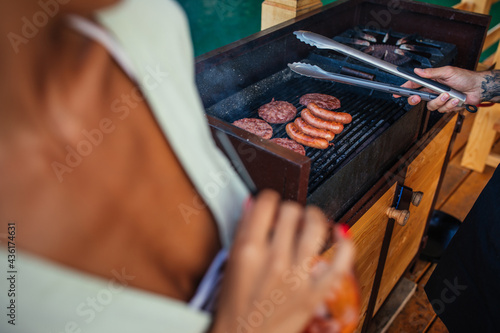 Couple making burgers outdoors and enjoying weekend together