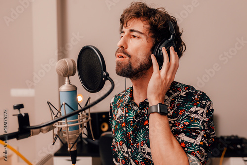 Foto Young singer laying down tracks in a recording home studio