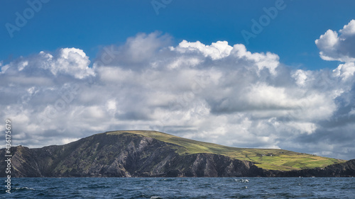Green fields and farms in morning light on top of Kerry Cliffs seen from boat on Atlantic Ocean, Portmagee, Iveragh Peninsula, Ring of Kerry, Ireland photo