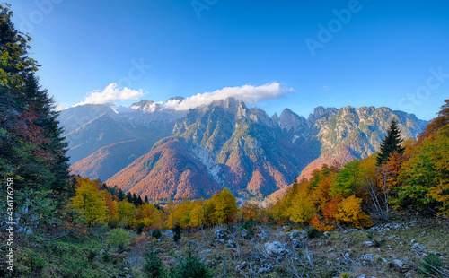 landscape of golden orange and red colors of autumn alps slovenia italy low clouds and first snow bright sunny day