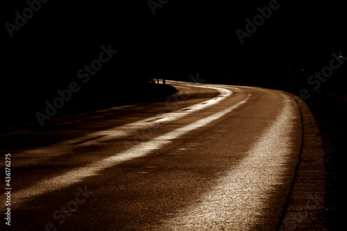 Fototapeta Naklejka Na Ścianę i Meble -  Strasse mit Kurve bei dunklem Sonnenlicht