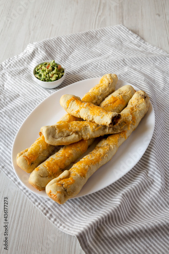 Homemade Cheesy Taco Breadsticks with Guacamole, low angle view.