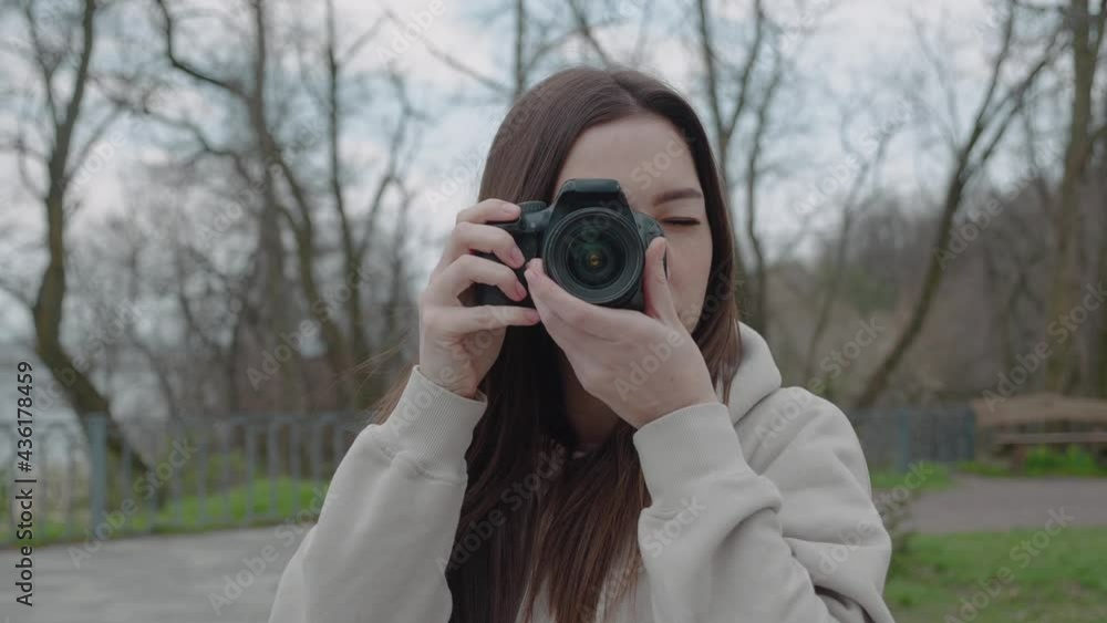 Happy inspired brunette woman making photos in a beautiful park, leisure and hobby front view Happy inspired brunette woman making photos in a beautiful park, leisure and hobby front view