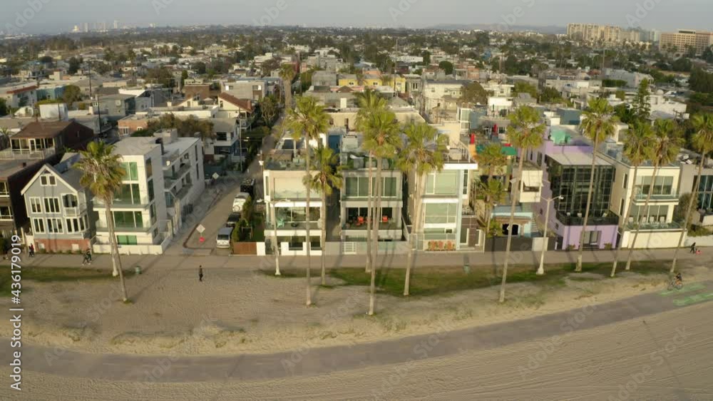 Aerial Ascending Shot Of People At Beach By City During Sunset, Residential District Against Sky - Los Angeles, California Aerial Ascending Shot Of People At Beach By City During Sunset, Residential District Against Sky - Los Angeles, California