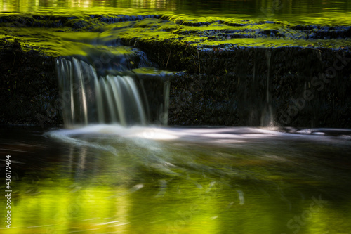 Fototapeta Naklejka Na Ścianę i Meble -  Cascading waterfall cascades in Estonia in green light at summertime