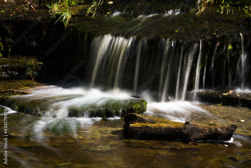 Fototapeta premium Cascading waterfall cascades in Estonia in green light at summertime