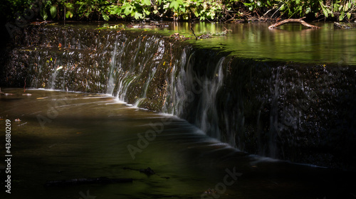 Cascading waterfall cascades in Estonia in green light at summertime