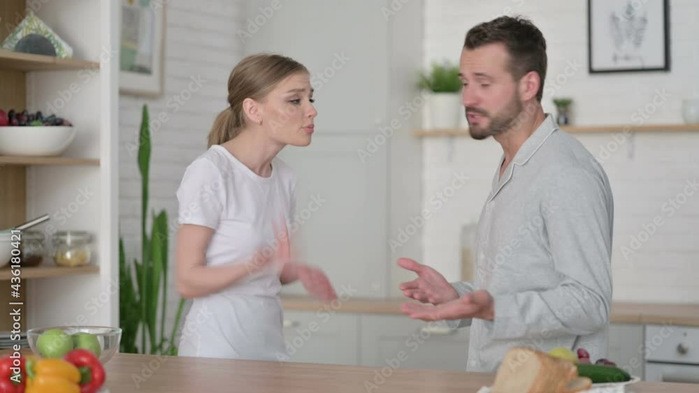 Man Arguing with Young Woman in Kitchen Man Arguing with Young Woman in Kitchen