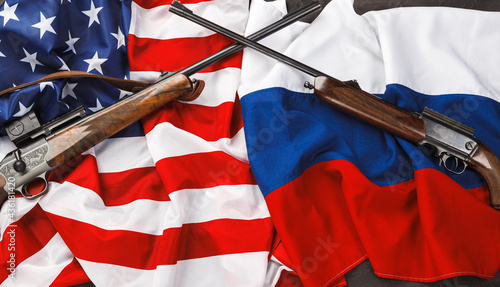 Usa flag and Russia flag background with two crossed shotguns photo