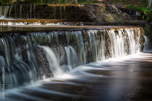 Fototapeta Naklejka Na Ścianę i Meble -  Cascading waterfall cascades in Estonia in green light at summertime