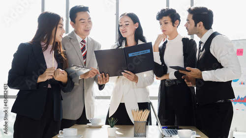 Five diversity, asian and caucasian, businessmen standing and reading file of insurance document